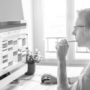 Mitarbeiter arbeitet am Computer mit Projektübersicht im Büro